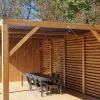 Schaffung eines Sichtschutzes auf einer bioklimatischen Pergola mit SUNDIY XL-Mechaniken in der Farbe Sandbeige und Lamellen aus Douglasienholz
